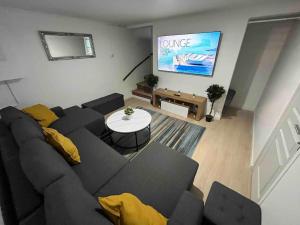 a living room with a couch and a large screen at P1- Maison 2min metro PARIS-EXPO 3 chambres 3 lits in Châtillon