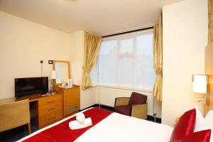 um quarto de hotel com uma cama e uma televisão em Acorn Lodge Hotel Gatwick & Parking em Horley