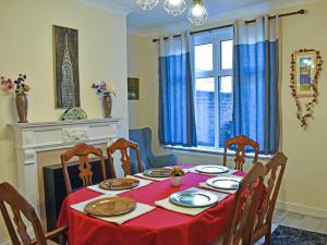 a dining room table with a red table cloth and chairs at Seymour House in Bishop Auckland