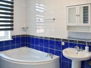 a blue and white bathroom with a tub and a sink at Seymour House in Bishop Auckland
