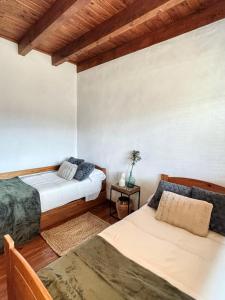 1 dormitorio con 2 camas y mesa en Villa Mirador, en Manzanera