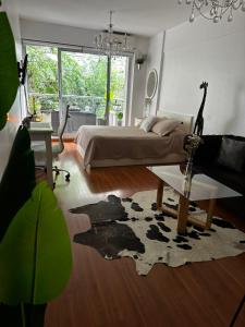 una camera con letto, tavolo e tappeto di MINIMO DE RESERVA 3 NOCHES Hermoso Monoambiente en Belgrano Buenos Aires a Buenos Aires