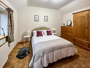 Byre Cottage في بيلينغشورست: غرفة نوم بسرير كبير وخزانة