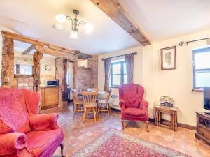 a living room with red furniture and a table at The Corn House - Uk45530 in Buildwas