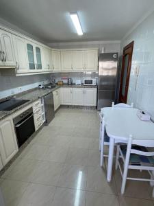 a kitchen with white cabinets and a white table at Magnífico Sol Paraíso in Adeje