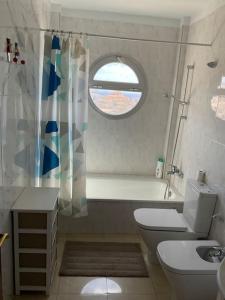 a bathroom with a toilet and a sink and a window at Magnífico Sol Paraíso in Adeje
