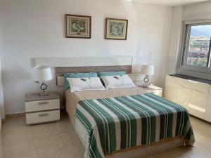 a bedroom with a bed with a green and white blanket at Magnífico Sol Paraíso in Adeje +12 photos