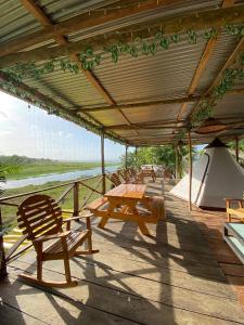 a wooden deck with a picnic table and a tent at Bayano Ecolodge in Chepo