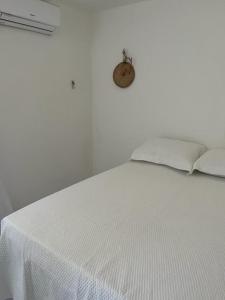 a bedroom with a white bed with a white bedspread at Casa Sertão Xingó in Piranhas