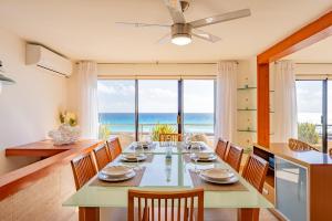 Amazing Caribbean Ocean view at Villas Marlin in Cancun في كانكون: غرفة طعام مع طاولة وكراسي والمحيط