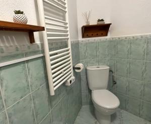 a small bathroom with a toilet and a window at Alojamiento El Pilar in Güéjar-Sierra +30 photos