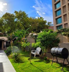 un jardín con un cubo de basura y una parrilla en "Casa Amalia Apartamentos" Ubicación Privilegiada con Jardín en Mendoza