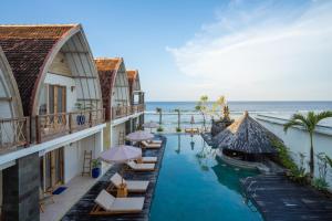 Batununggul的住宿－ALANA PENIDA HOTEL，一个带椅子和船只的游泳池的度假酒店