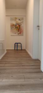 an empty room with a chair and a painting on the wall at Modern Apartment with great terasse and mountain view in Braşov