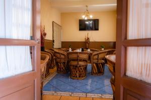 ein Zimmer mit Tisch, Stühlen und Fernseher in der Unterkunft Hotel Estefania in Morelia