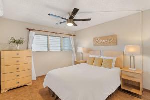 a bedroom with a white bed and a ceiling fan at Island Surf 304 - Renovated, Ocean Views, Split AC in Kihei +111 photos