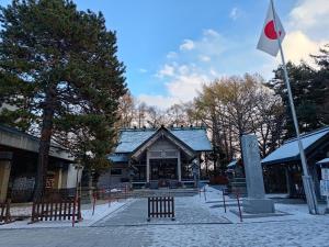 a building with a flag in front of it at Anna's House 駐車無料ワンフロア貸し切り in Sapporo