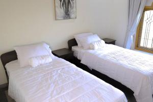two beds sitting next to each other in a room at Lone Star Residence in Jaffna