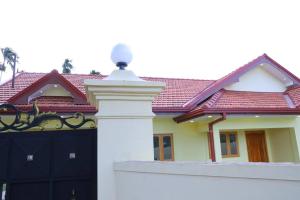 a house with a black gate and a red roof at Lone Star Residence in Jaffna