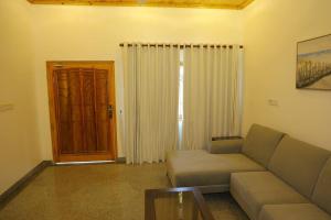 a living room with a couch and a wooden door at Lone Star Residence in Jaffna