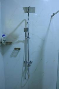 a shower in a white bathroom with a shower at Lone Star Residence in Jaffna