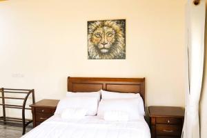 a bed with a picture of a lion on the wall at Lone Star Residence in Jaffna