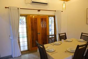 a dining room with a table and chairs and a door at Lone Star Residence in Jaffna