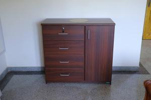 a wooden cabinet with drawers in a room at Lone Star Residence in Jaffna