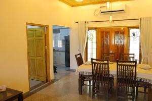 a dining room with a table and wooden chairs at Lone Star Residence in Jaffna