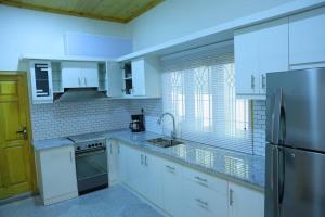 a kitchen with white cabinets and a stainless steel refrigerator at Lone Star Residence in Jaffna