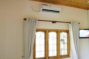 a room with two windows and a air conditioner at Lone Star Residence in Jaffna