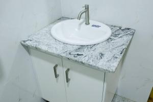 a bathroom with a white sink on a counter at Lone Star Residence in Jaffna