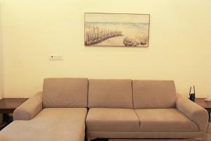 a couch in a living room with a painting on the wall at Lone Star Residence in Jaffna