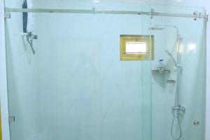 a bathroom with a shower with a glass door at Lone Star Residence in Jaffna