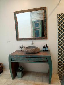 a bathroom with a sink and a mirror at The Blue Joglo Jogja in Yogyakarta