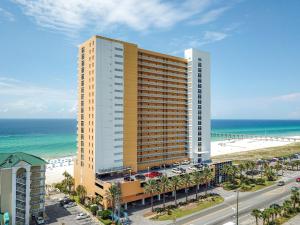 a tall building next to the beach and the ocean at Beachfront Stunning view 100 ft long swimming pool in Panama City Beach