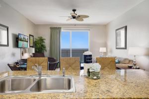 uma cozinha com um lavatório e uma sala de estar em Beachfront Stunning view 100 ft long swimming pool em Panama City Beach