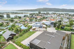 una vista aérea de un suburbio con un cuerpo de agua en Upper Bow Retreat - Raglan Holiday Apartment en Raglan