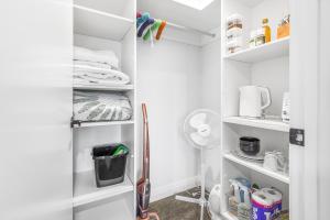 a walk in pantry with white shelves at Upper Bow Retreat - Raglan Holiday Apartment in Raglan