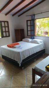 a bedroom with two beds and a window at Pousada João e Maria in Trindade