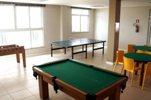 Habitación con 2 mesas de ping pong y sillas en Recanto da Gabriela - Apartamento para temporada na zona sul de ilhéus en Ilhéus