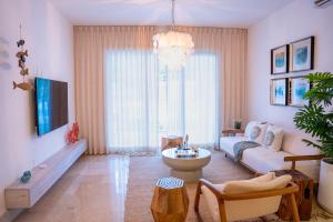 a living room with a couch and a table at Fortunity Beach Tower-2 BDR with pool view in San Felipe de Puerto Plata