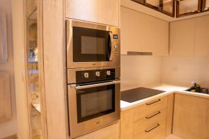 a kitchen with a stainless steel oven and microwave at Fortunity Beach Tower-2 BDR with pool view in San Felipe de Puerto Plata