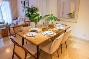 a wooden table with chairs and a dining room at Fortunity Beach Tower-2 BDR with pool view in San Felipe de Puerto Plata