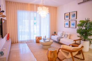 a living room with a couch and a table at Fortunity Beach Tower-2 BDR with pool view in San Felipe de Puerto Plata
