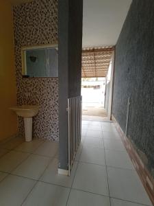 um corredor com um lavatório e uma porta para um quarto em Casa em iguaba grande em Iguaba Grande
