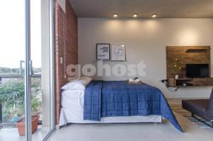 a bedroom with a bed with a blue comforter at Comfy Loft Bbq Terrace And Balcony in Asuncion