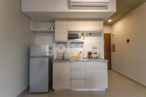 a kitchen with white cabinets and a refrigerator at Comfy Loft Bbq Terrace And Balcony in Asuncion