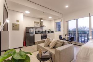 a living room with a couch and a kitchen at Wonderful Studio In The City, Close To Sh Del Sol in Asunción