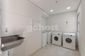 a bathroom with three washing machines and a sink at Comfortable Villa Morra Loft in Asunción